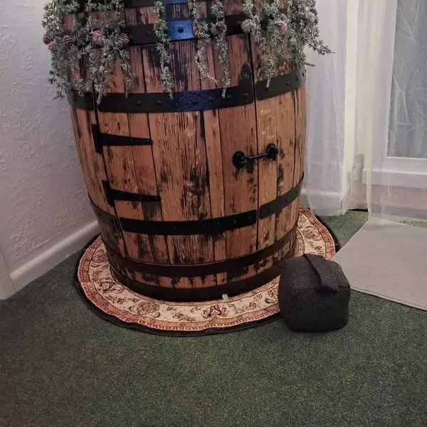 A barrel storage table decorated with a garland, photographed by michelle