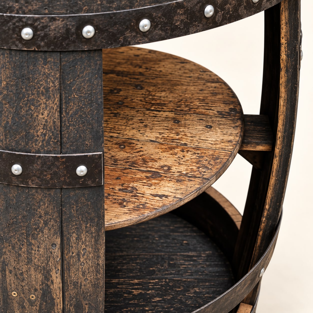 Close-up of the dark oak barrel table's circular shelf, stave support and riveted steel hoop